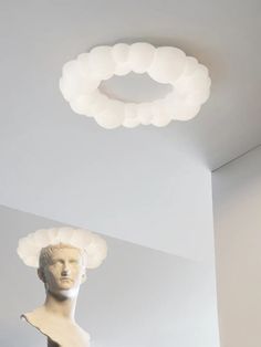 a white sculpture sitting under a circular light fixture