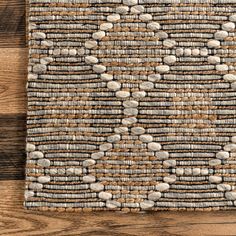 an area rug with rocks on it and wood flooring in the background, top view