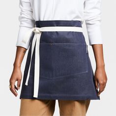 a woman in a white shirt is wearing a denim skirt with a tie around the waist