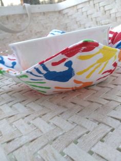 two colorful bowls sitting on top of a woven table