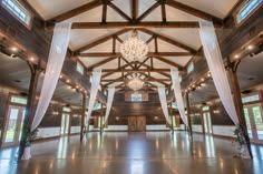 the inside of a large building with white drapes and chandelier hanging from the ceiling