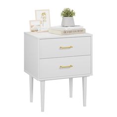 a white nightstand with two drawers and a potted plant sitting on top of it