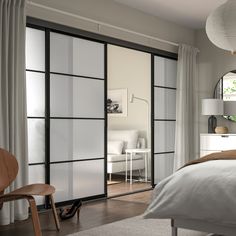 a bedroom with sliding glass doors and white furniture