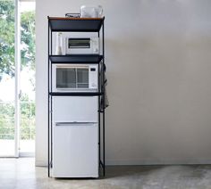 a white refrigerator freezer sitting next to a microwave oven on top of a shelf