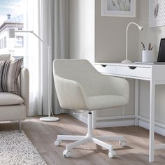 a white desk chair sitting in front of a laptop computer on top of a table