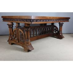 an ornately carved wooden table on carpeted floor