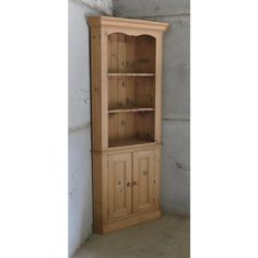 a tall wooden cabinet sitting next to a wall