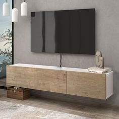 a large flat screen tv mounted to the side of a wooden cabinet in a living room