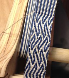 a blue and white tie sitting on top of a piece of wood