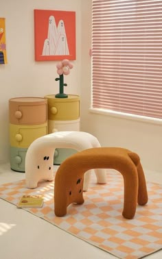 three stuffed animals sitting on top of a rug in front of a window with blinds