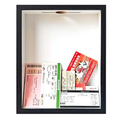 two tickets are sitting in a shadow box on the wall next to some other items