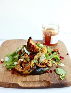 a wooden cutting board topped with vegetables and sauce