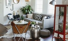 a living room filled with lots of furniture next to a tall clock on the wall