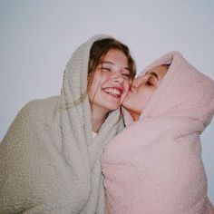 two women wrapped in blankets are smiling at the camera