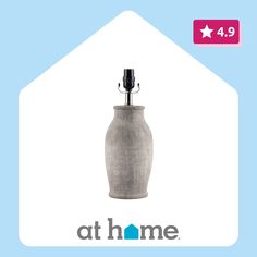 a gray vase sitting on top of a blue and white background with the words at home above it