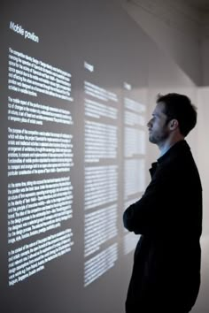 a man standing in front of a wall with text on it