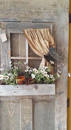 an old window with flowers and a hat on it