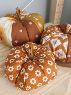 three decorative pumpkins sitting on top of a wooden table