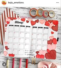 a planner with hearts on it next to some scissors and other items that include tape