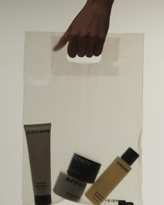 a person's hand is reaching into a clear bag with various skin care products on it