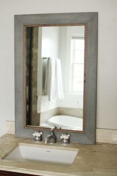 a bathroom sink sitting under a large mirror