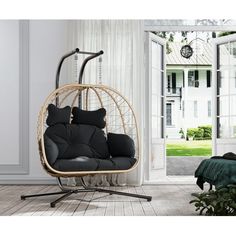 a hanging chair with pillows in front of an open door