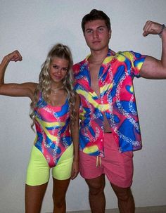 the man and woman are posing together in their swimsuits, with one arm raised