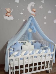 a baby's crib with teddy bears on the wall and clouds above it