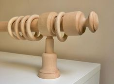 a close up of a wooden object on a white table with a wall in the background