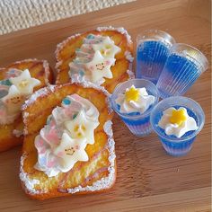 small pastries with icing and sprinkles are on a wooden table