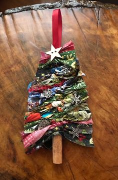 a christmas tree made out of fabric on top of a wooden table with a red ribbon