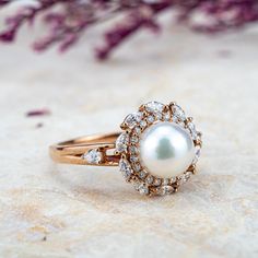 Embrace elegance with the Pearl Blossom Ring, featuring a lustrous Akoya pearl cradled in 14K solid gold. Handcrafted petals of precision-cut moissanite encircle the natural gem, reflecting a commitment to original, high-end design. 🌟 ITEM DESCRIPTION 🌟Handmade with meticulous craftsmanship.Metal Options: Solid 14K, and 18K Gold.Gold Colors Available: Rose gold, Yellow gold, White gold.💍 ENGAGEMENT RING 💍Center Stone: Akoya PearlSize: ≈7.4mmRound-ShapedAccent Stones:MoissaniteCut: Marquise&RoundColor Options: G-H / DEFClarity: VS-SI / VVS-VS✦ Width of the gold band -1.6 mm Pearl Rings In Gold, Custom Gold Rings, Pearl Diamond Ring, Rings In Gold, Gold For Women, Rings Anniversary, Pearl Rings, Pearl And Diamond Ring, Full Eternity Ring