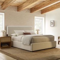 a bedroom with white walls and wooden beams