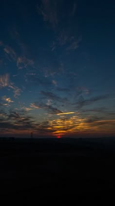 the sun is setting behind some clouds in the sky