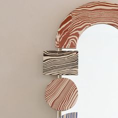 a mirror that is on the side of a wall with some wood pieces in front of it