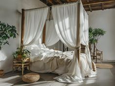 a bed with white sheets and drapes in a room next to a potted plant