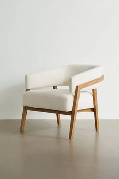 a white chair sitting on top of a hard wood floor next to a white wall