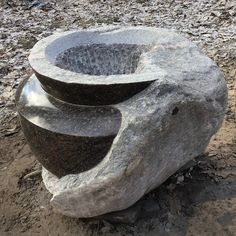 three stone bowls are stacked on top of each other in the middle of some dirt