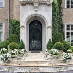 an entrance to a large brick building with white flowers and pumpkins on the steps