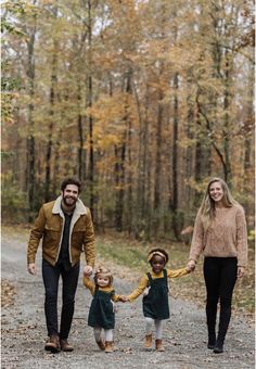 an adult and two children walking down a path in the woods with their parents holding hands