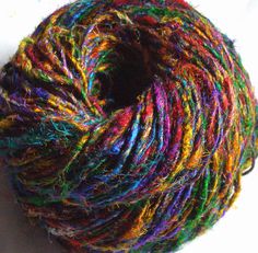 a ball of multicolored yarn sitting on top of a white surface