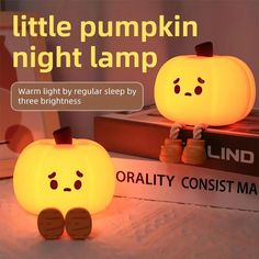 two little pumpkin night lamps sitting on top of a table