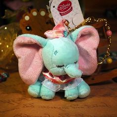 an elephant keychain sitting on top of a table next to other stuffed animals