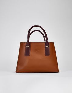 The Cognac Hudson Tote is a luxurious vegan leather bag that is effortlessly stylish and incredibly versatile. It can be used as a shoulder bag or a crossbody bag, depending on the occasion. This multi-way purse is a great choice for those looking to add a touch of sophistication and elegance to their wardrobe. Material: Genuine Soft Vegan Leather Dimensions : 33 L x 14 w x 23 h Pockets: 6 Interior compartments Straps : 2 chocolate brown handles & 1 chocolate brown crossbody strap Locks: 2 snap Timeless Brown Shoulder Bag With Handle Drop, Luxury Cognac Shoulder Bag With Double Handle, Elegant Brown Satchel With Detachable Handle, Elegant Brown Box Bag With Double Handle, Chic Top Handle Bag In Cognac, Chic Cognac Top Handle Bag, Elegant Cognac Tote Shoulder Bag, Timeless Brown Bag With Handle Drop, Timeless Cognac Satchel With Handle Drop