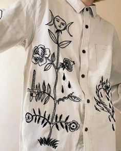 a person wearing a white shirt with flowers on it