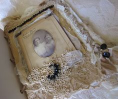 an old book with lace and buttons on it