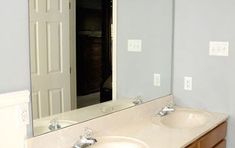 a bathroom with two sinks and a large mirror