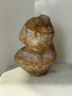 a stone sculpture sitting on top of a white surface