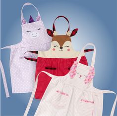 three aprons with different designs on them, one has a cat and the other has a deer