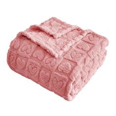 a pink blanket with hearts on it is folded up in front of a white background